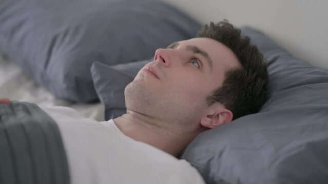 Worried Man Awake in Bed Thinking, Close up
