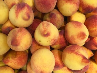 Background of ripe peaches displayed for sale in a supermarket.
