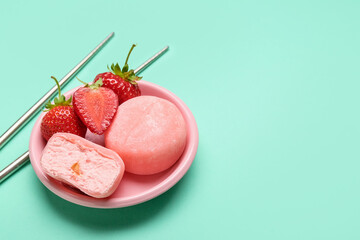 Plate with delicious mochi, strawberry and chopsticks on color background