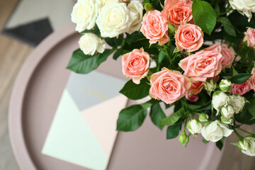 Bouquet of beautiful fresh roses on table in room, closeup