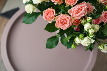 Bouquet of beautiful fresh roses on table in room, closeup