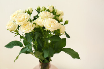 Obraz na płótnie Canvas Vase with bouquet of beautiful fresh roses near white wall, closeup