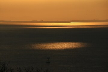 The sight of the sunrise, the silhouette of the sunrise and the brilliance of the sea surface. 