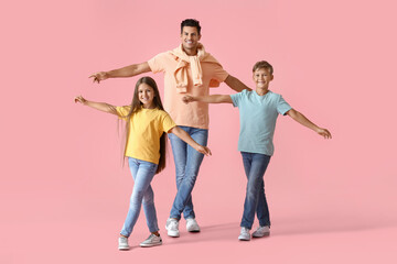 Happy dancing man and his children on color background