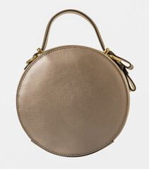 Round-shaped leather handbag in gold color. Model with one handle