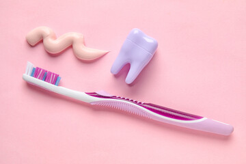 Sample of paste, plastic tooth and brush on pink background
