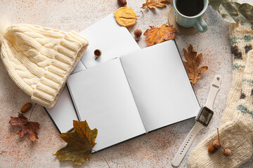 Blank books, cup of coffee wristwatch, socks and autumn decor on light background