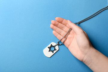 Hand with military tag of Israeli soldier on color background