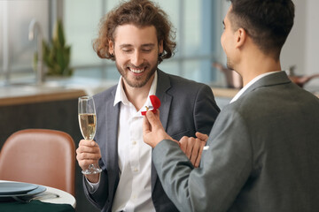 Young gay proposing to his boyfriend on romantic date