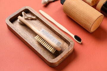 Wooden board with massage brush on color background, closeup