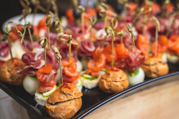Catering table, beautifully decorated banquet with variety of with different food snacks and appetizers on corporate birthday party event or wedding celebration, canape, delicatessen setting