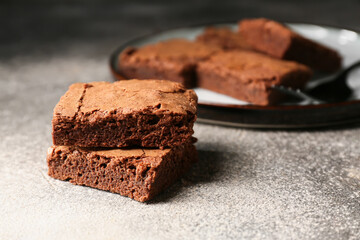 Pieces of tasty chocolate brownie on grey background