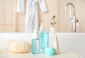 Sponge and cosmetic products on table in bathroom