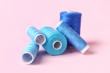 Blue sewing thread spools on color background