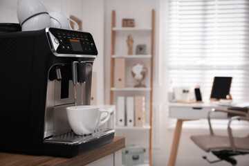 Modern espresso machine pouring coffee into cup in office. Space for text