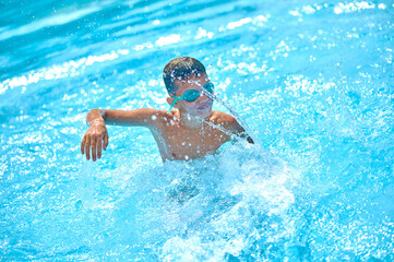 Boy in pool swimming raising his hand