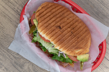 Overhead view of enormous carnitas torta sandwich is loaded and overflowing with chopped...