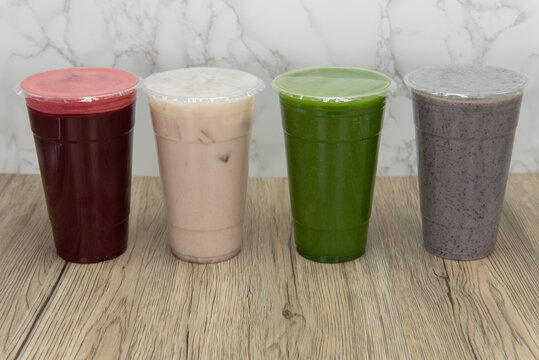 Blended line of colorful smoothies in large cups makes choosing which one to drink a difficult option