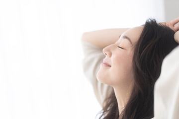 起床/朝日を浴びる女性。