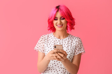 Stylish young woman with mobile phone on pink background
