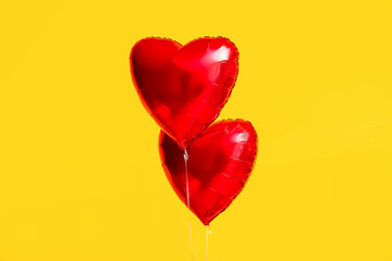 Beautiful heart-shaped balloons for Valentine's Day celebration on yellow background