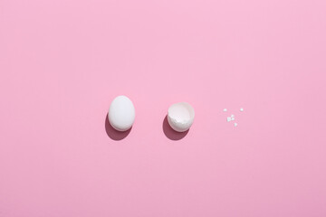 Easter egg and eggshell on color background