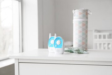 Baby monitors and bottle case on chest of drawers in light room
