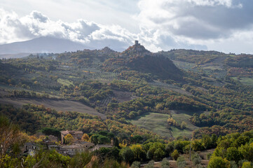 Naklejka premium Hiking on hills of Val d'Orcia near Bagno Vignoni, Tuscany, Italy. Tuscan landscape with cypress trees, vineyards, forests and ploughed fields in autumn.
