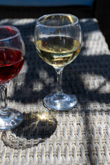 Two glasses of cold rose and white wines in lounge bar on sunny day