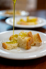 Tasting of Italian extra virgin olive oil with bread on organic farm in Tuscany, Italy