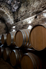 Medieval underground wine cellars with old red wine barrels for aging of vino nobile di Montepulciano in old town Montepulciano in Tuscany, Italy - obrazy, fototapety, plakaty