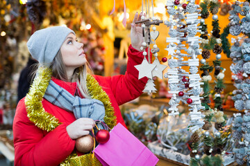 Young female near counter with xmas gifts on street market. High quality photo
