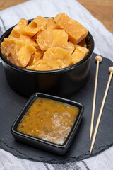Cheese tasting, small pieces of old Dutch hard cheese and bowl with homemade dill-mustard sauce