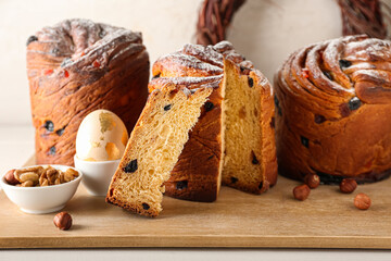 Wooden board with delicious Easter cakes on table