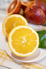 Sicilian sweet juicy yellow and red blood oranges with green leaves close up