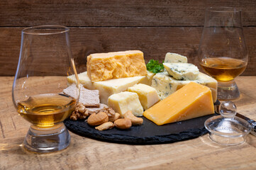 British drinks and food, glasses of Scotch whisky and cheeses collection, blue Stilton, Scottish coloured and English matured cheddar cheeses