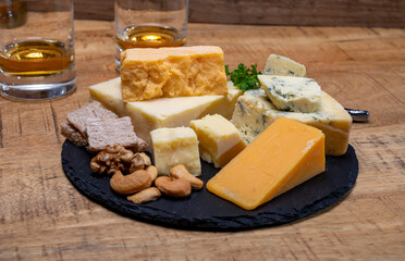 British drinks and food, glasses of Scotch whisky and cheeses collection, blue Stilton, Scottish coloured and English matured cheddar cheeses