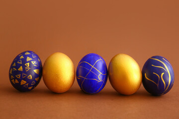 Stylish Easter eggs on brown background
