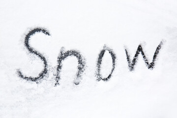 Word SNOW written on snow covered car