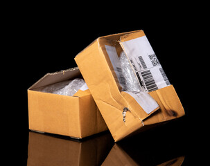 damaged cardboard parcel on black background