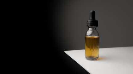bottle of essential oil with dropper on dark backround