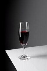 Elegant glass of red wine on gray background.