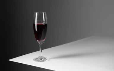 Elegant glass of red wine on gray background.