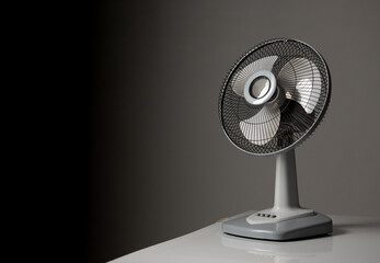 Gray electric fan on white table; Space for text