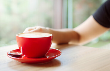 young woman sitting at the side window enjoy coffee at cafe