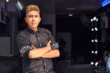Fototapeta na wymiar barbero en la entrada de su local comercial en latinoamerica