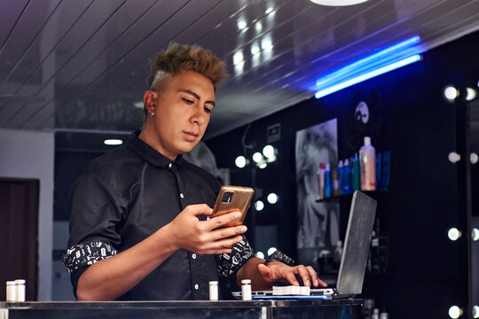 barbero agendando citas en sus dispositivos tecnol&oacute;gicos