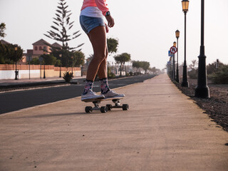 Unrecognizable skater woman legs going downhill on surfskate carver skateboard