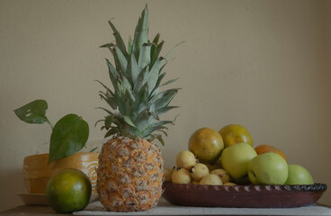 Fruits adorning the table along with a small plant that transmits serenity.