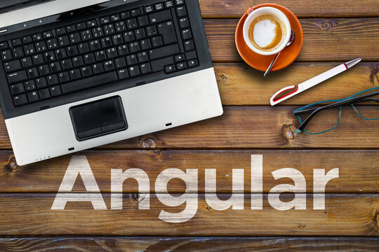 Angular web framework.. Word Angular on wooden desk with laptop
